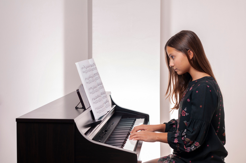 Girl playing the piano, girl learning piano, she is careful,